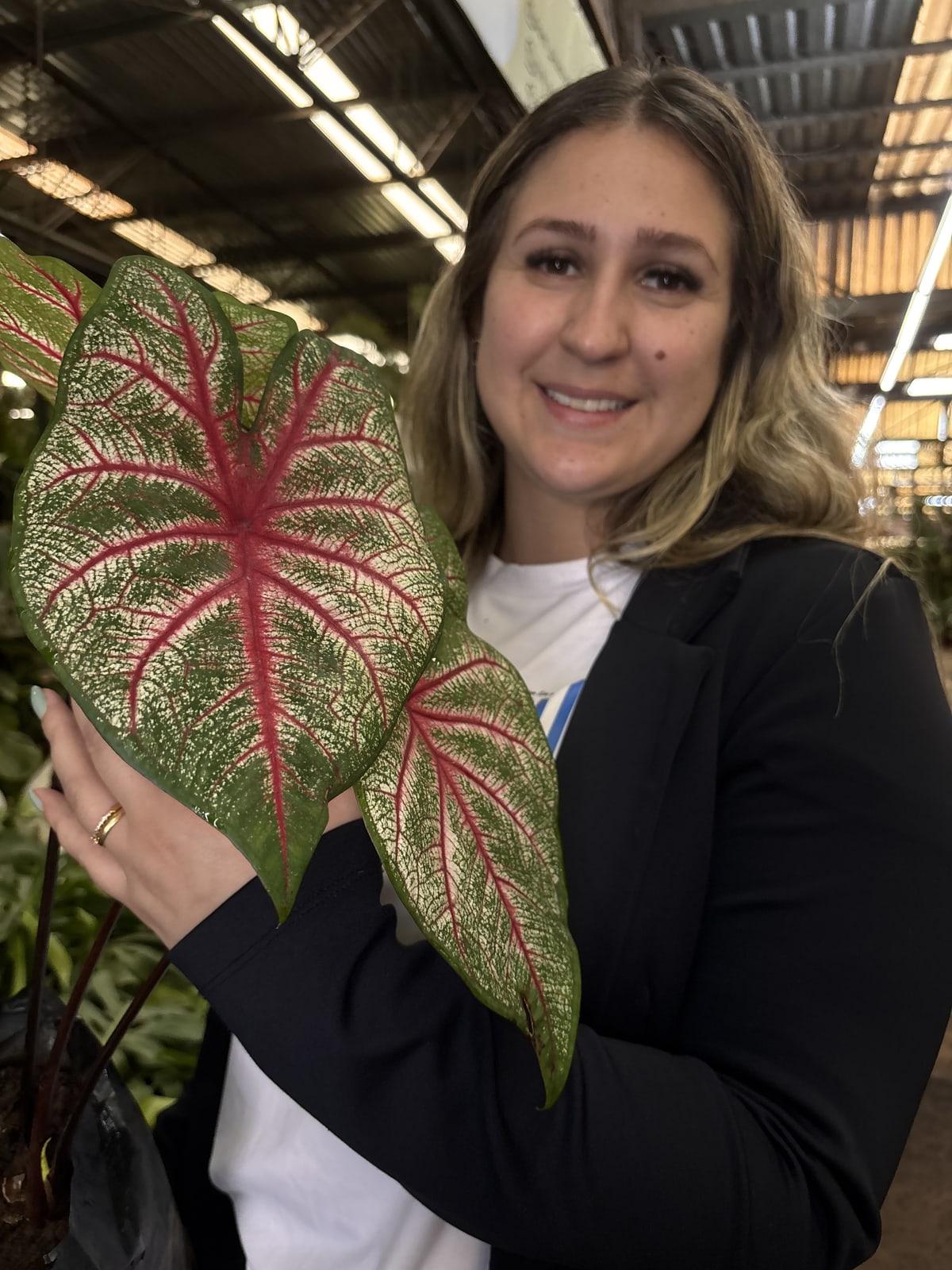 Caroline segurando um caládio no Mercado das Flores